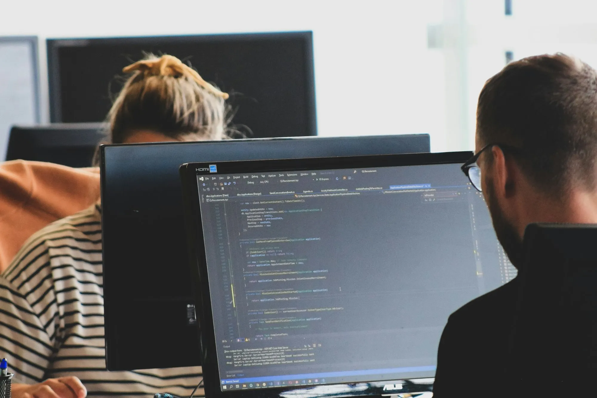 Engineers reviewing code on large monitors